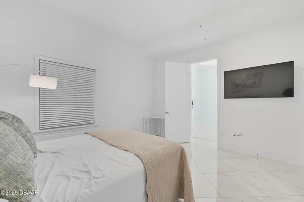 a bedroom with a bed and a flat screen tv