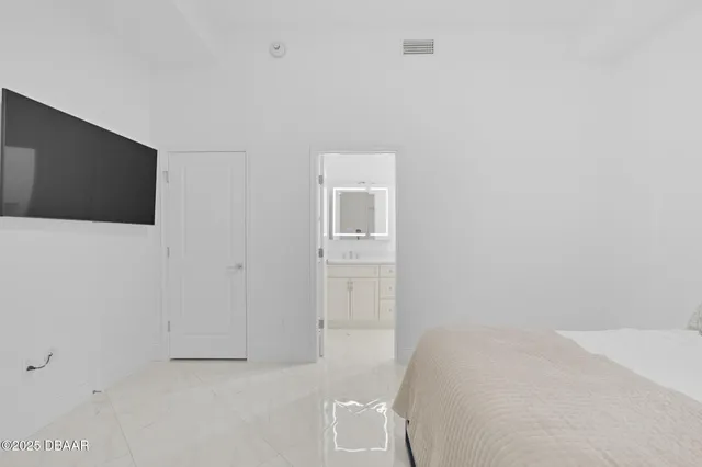 a bedroom with a bed and a flat screen tv