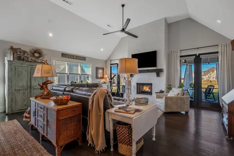 a living room with furniture a flat screen tv and a fireplace