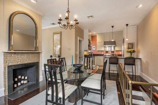 a view of a dining room with furniture a fireplace and chandelier