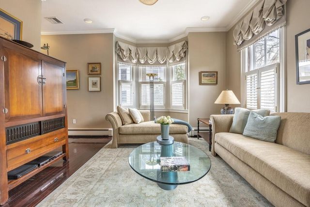 a living room with furniture fireplace and large windows