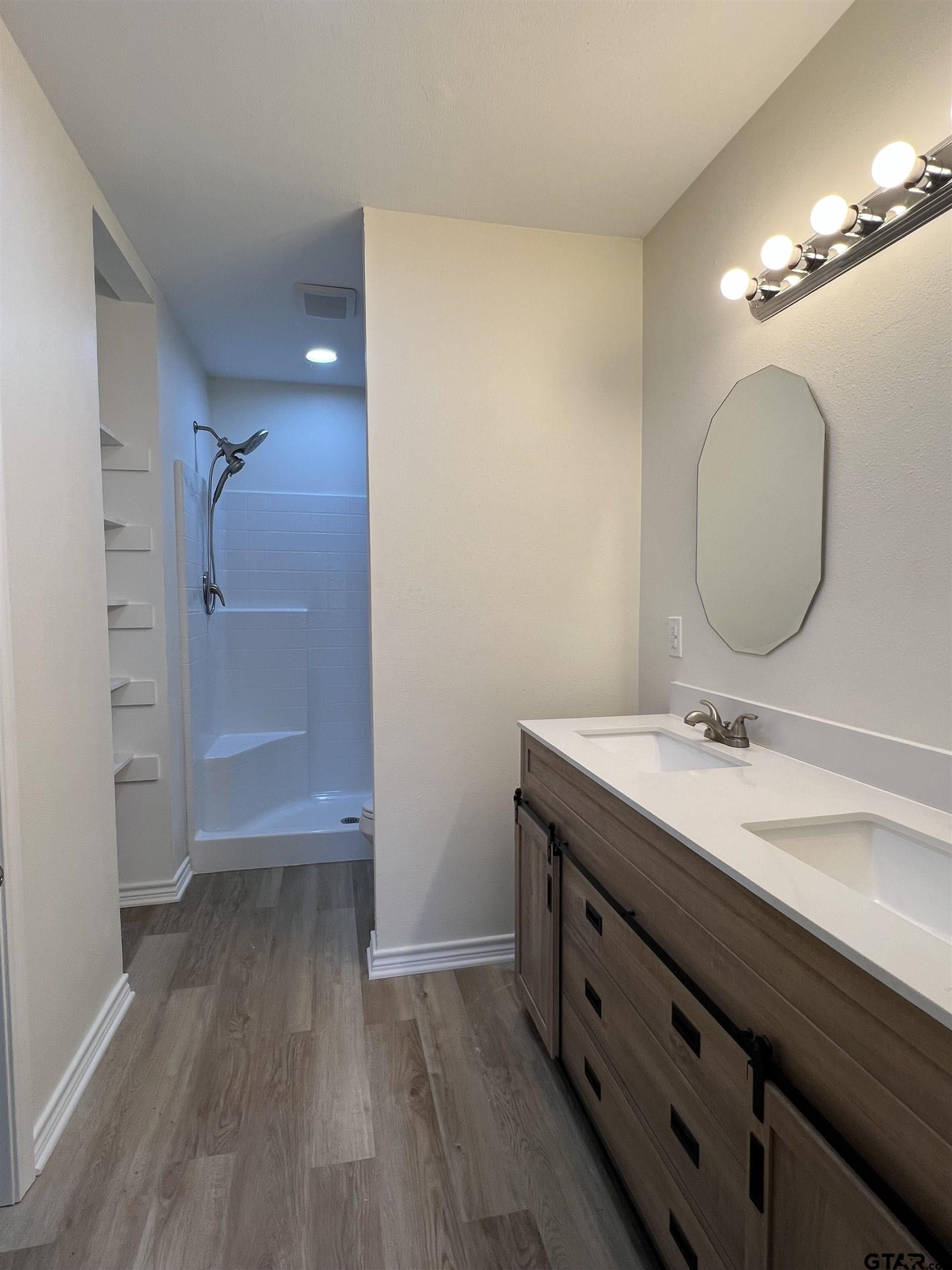 125 Pecan Drive Bullard, TX 75757 - Photo 11 of 16 a bathroom with a sink a mirror and a shower