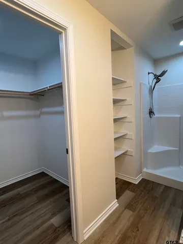 a view of walk in closet with empty racks