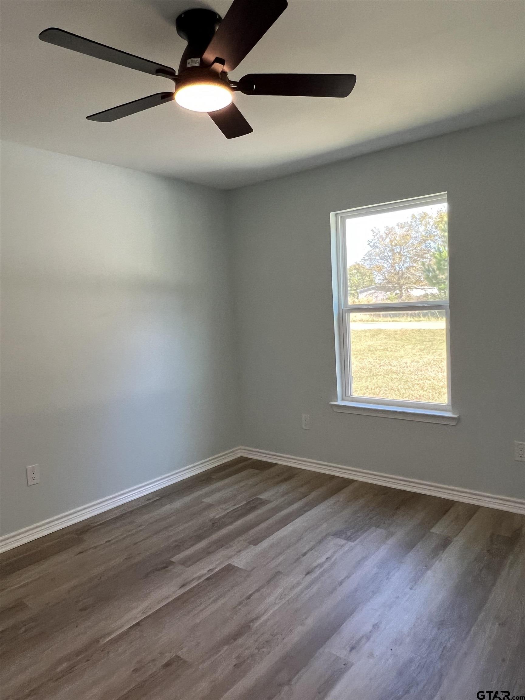 125 Pecan Drive Bullard, TX 75757 - Photo 13 of 16 a view of an empty room with wooden floor and a window