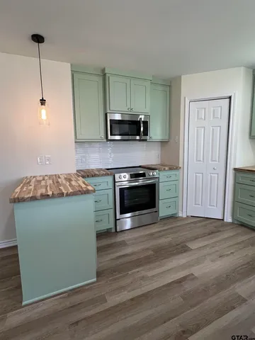 a kitchen with granite countertop a stove and a wooden floors