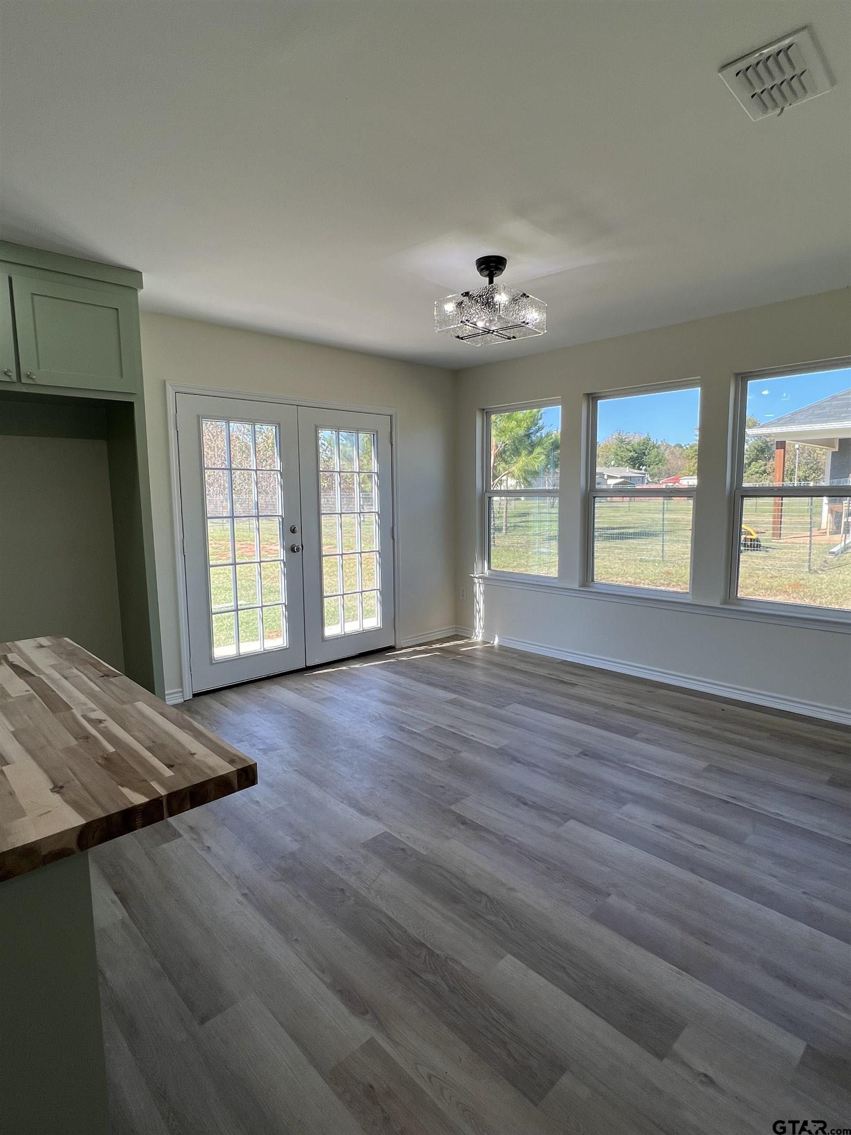 125 Pecan Drive Bullard, TX 75757 - Photo 8 of 16 a view of an empty room with a window and wooden floor
