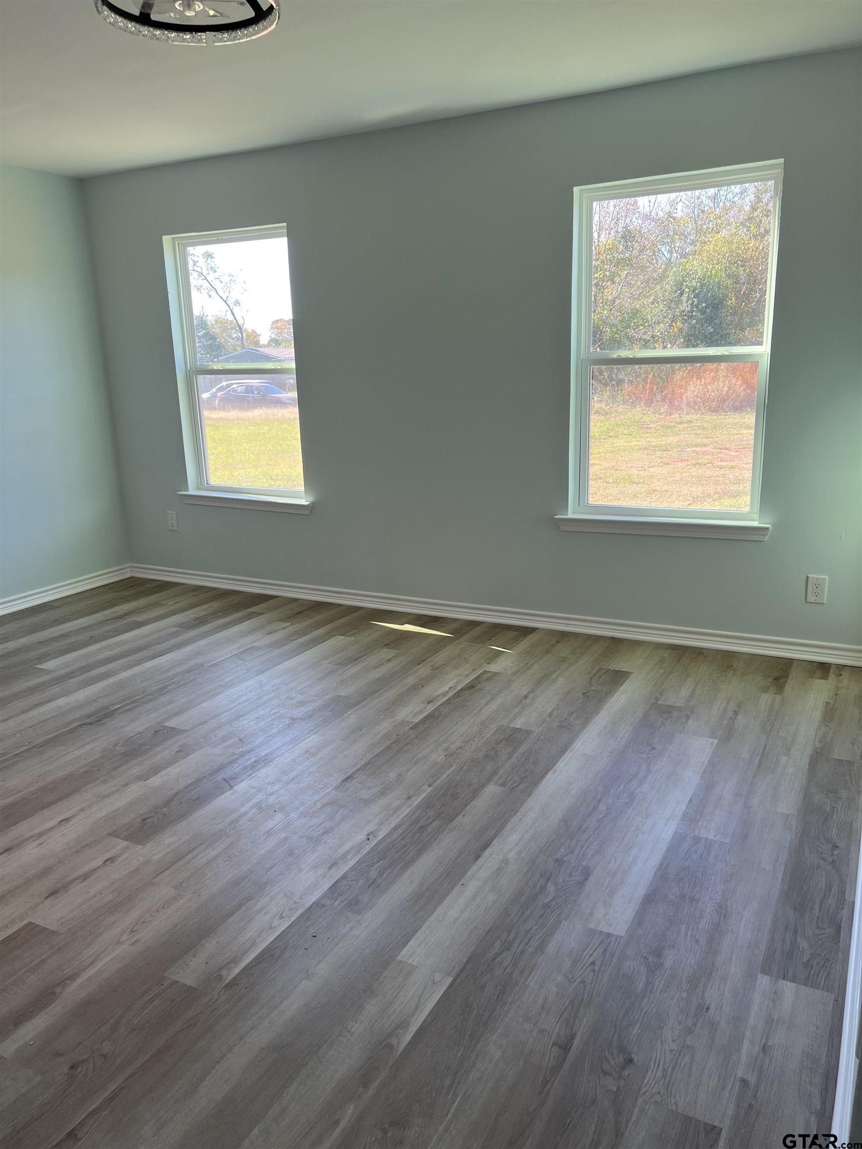 125 Pecan Drive Bullard, TX 75757 - Photo 10 of 16 a view of an empty room with wooden floor and a window