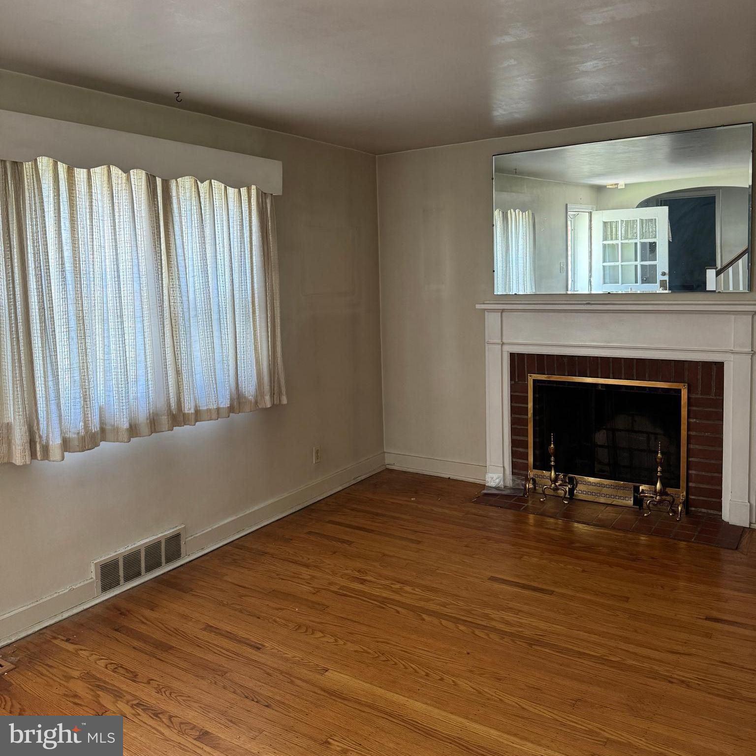 407 Willow Road Oreland, PA 19075 - Photo 4 of 30 a view of an empty room with wooden floor fireplace and a window