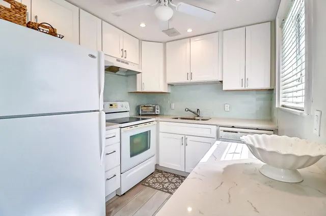 a kitchen with a white cabinets and white appliances