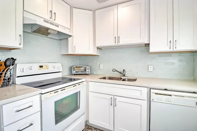 a kitchen with stainless steel appliances granite countertop white cabinets sink and dishwasher