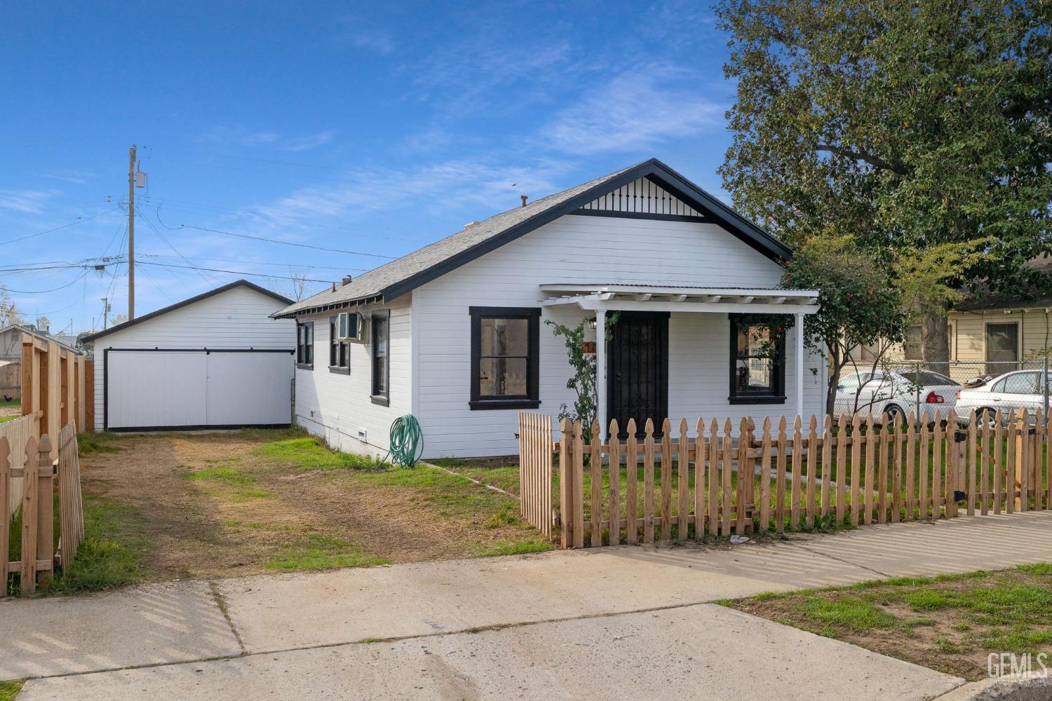 a view of a house with wooden fence next to a yard
