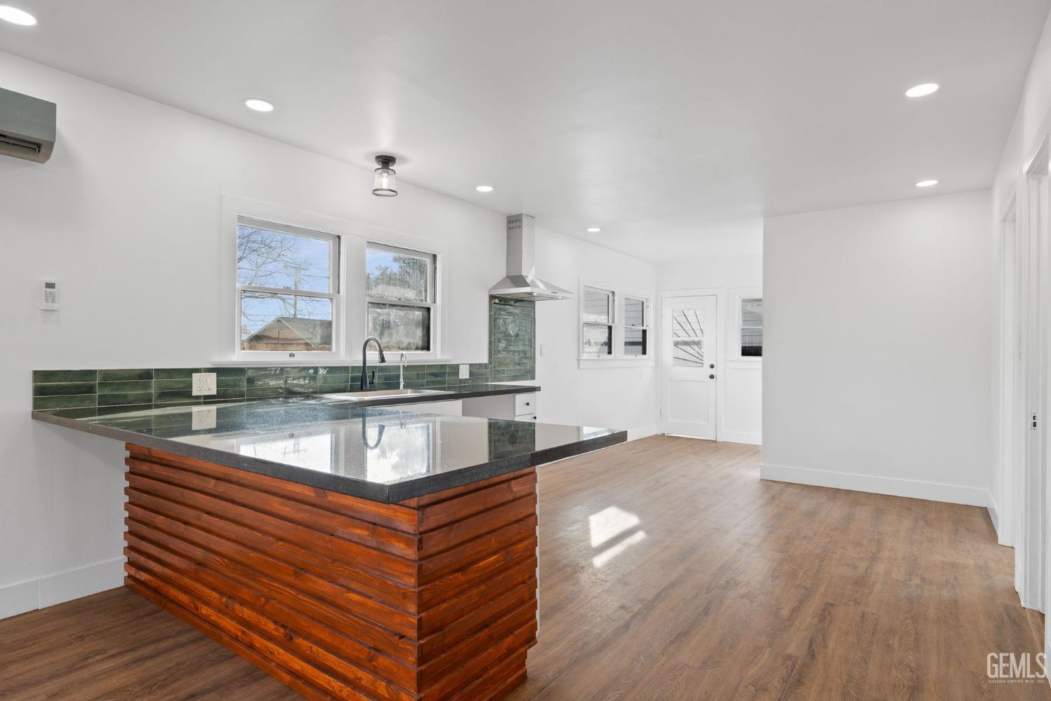Undisclosed Address Bakersfield, CA 93308 - Photo 6 of 21 a kitchen with stainless steel appliances granite countertop a sink a stove and a wooden floors