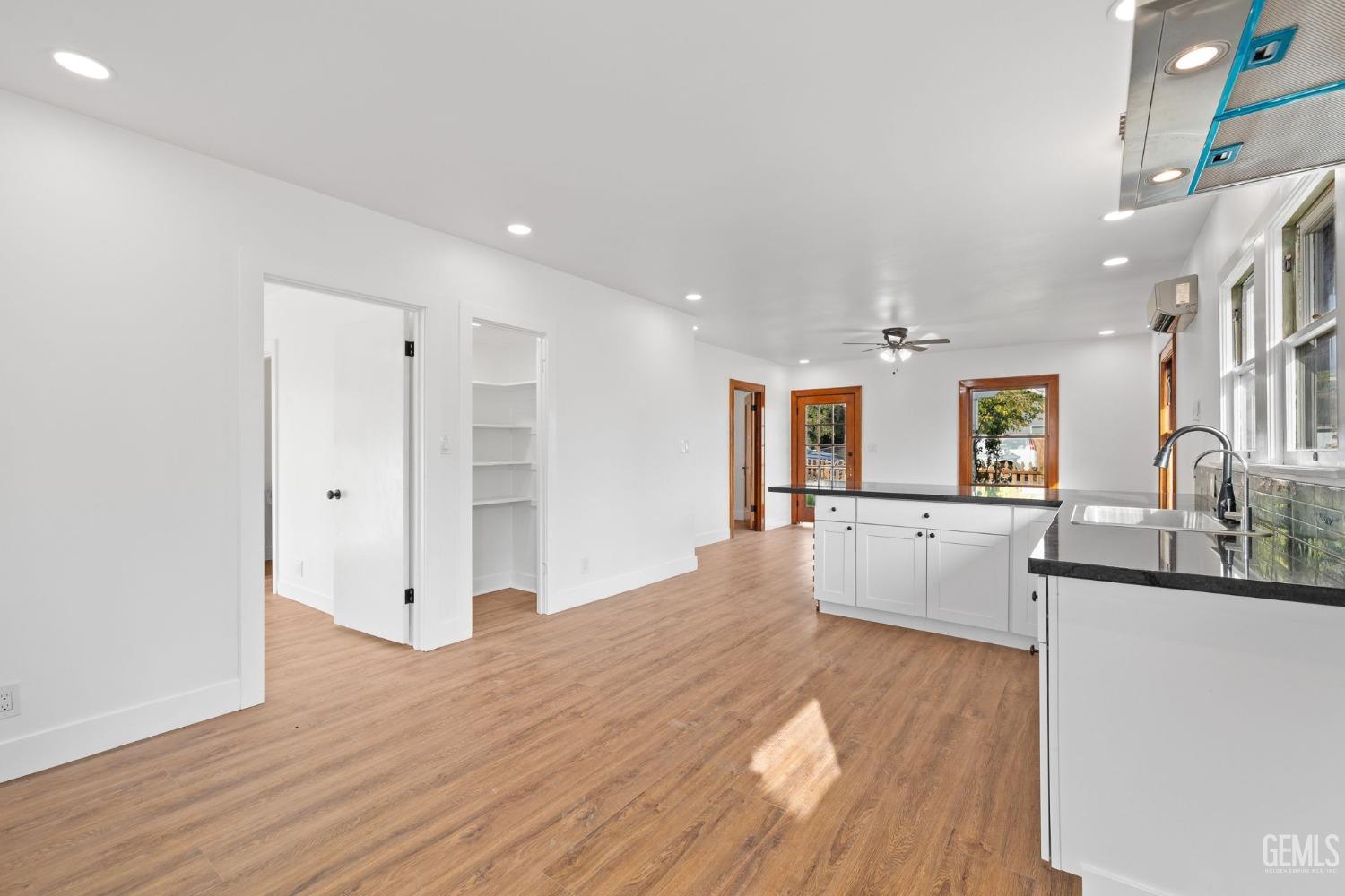 Undisclosed Address Bakersfield, CA 93308 - Photo 8 of 21 a large white kitchen with wooden floor and a sink
