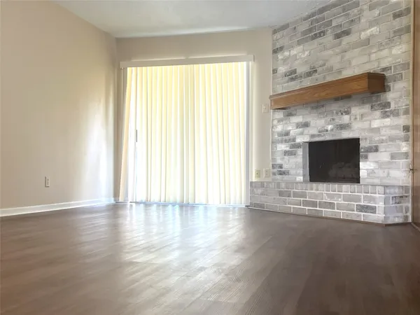 a view of empty room with wooden floor and fireplace