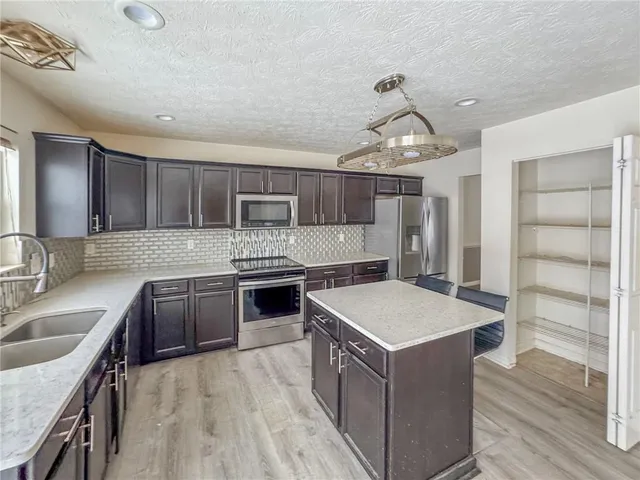 a kitchen with a stove sink and cabinets