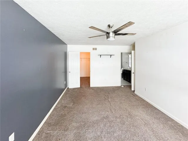 an empty room with a ceiling fan and a window