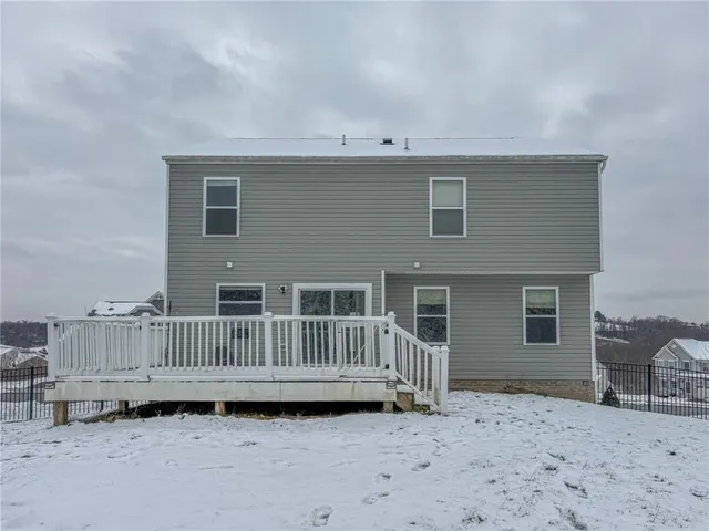 a view of a house with a wooden deck and floor to ceiling window