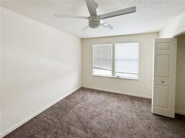 an empty room with a ceiling fan and a window