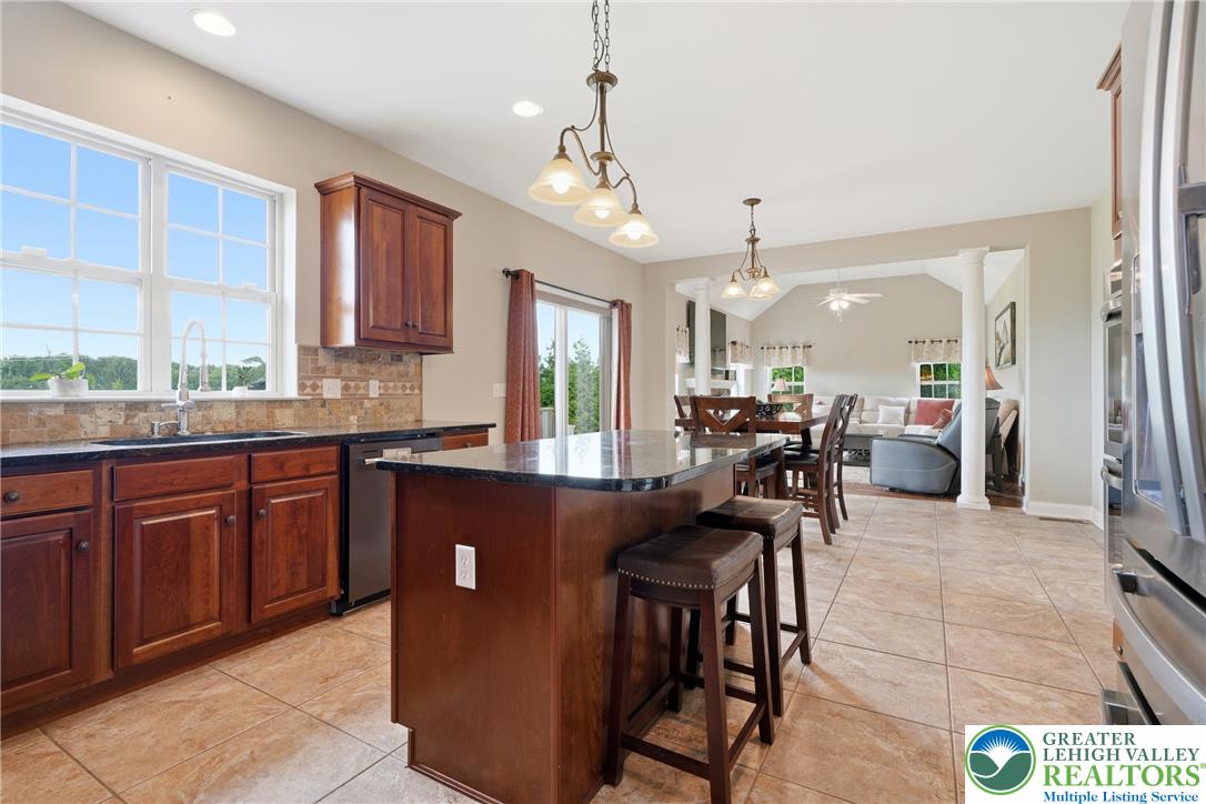 245 East Dell Road Bath, PA 18014 - Photo 17 of 99 An inviting open-concept kitchen features a large island and ample counter space, seamlessly flowing into a sun-filled dining and living area.