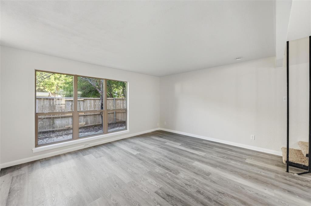 2702 Douglas Avenue, Unit 121 Dallas, TX 75219 - Photo 19 of 34 an empty room with wooden floor and windows