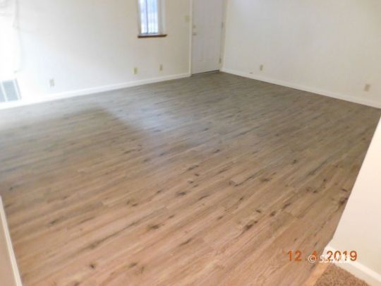 712 North Florence Street Ridgecrest, CA 93555 - Photo 8 of 14 an empty room with wooden floor and windows