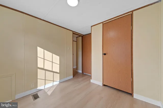 an empty room with windows and closet