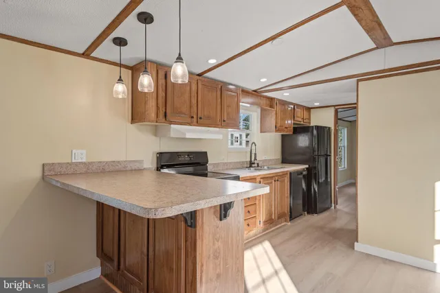 a kitchen with stainless steel appliances granite countertop a sink a refrigerator and a stove