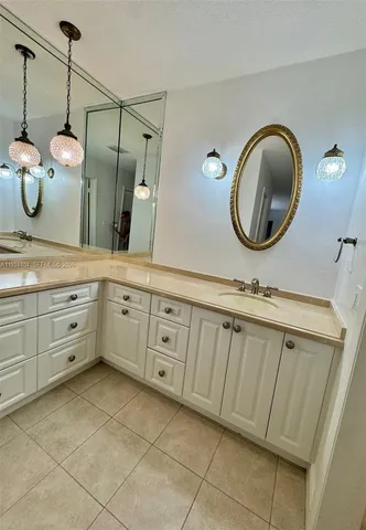 a bathroom with a granite countertop sink a mirror and vanity