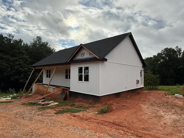 a white house with tall trees in the background