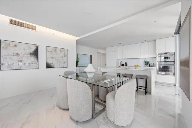 a living room with furniture and floor to ceiling windows