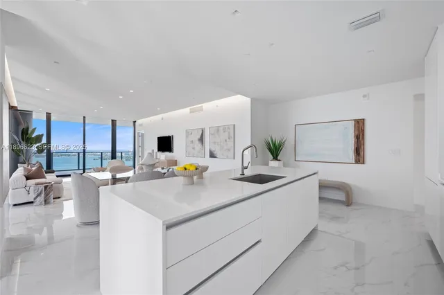 a view of a hallway with wooden floor and a bathroom