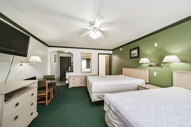 a bedroom with double bed and a flat tv screen on dresser