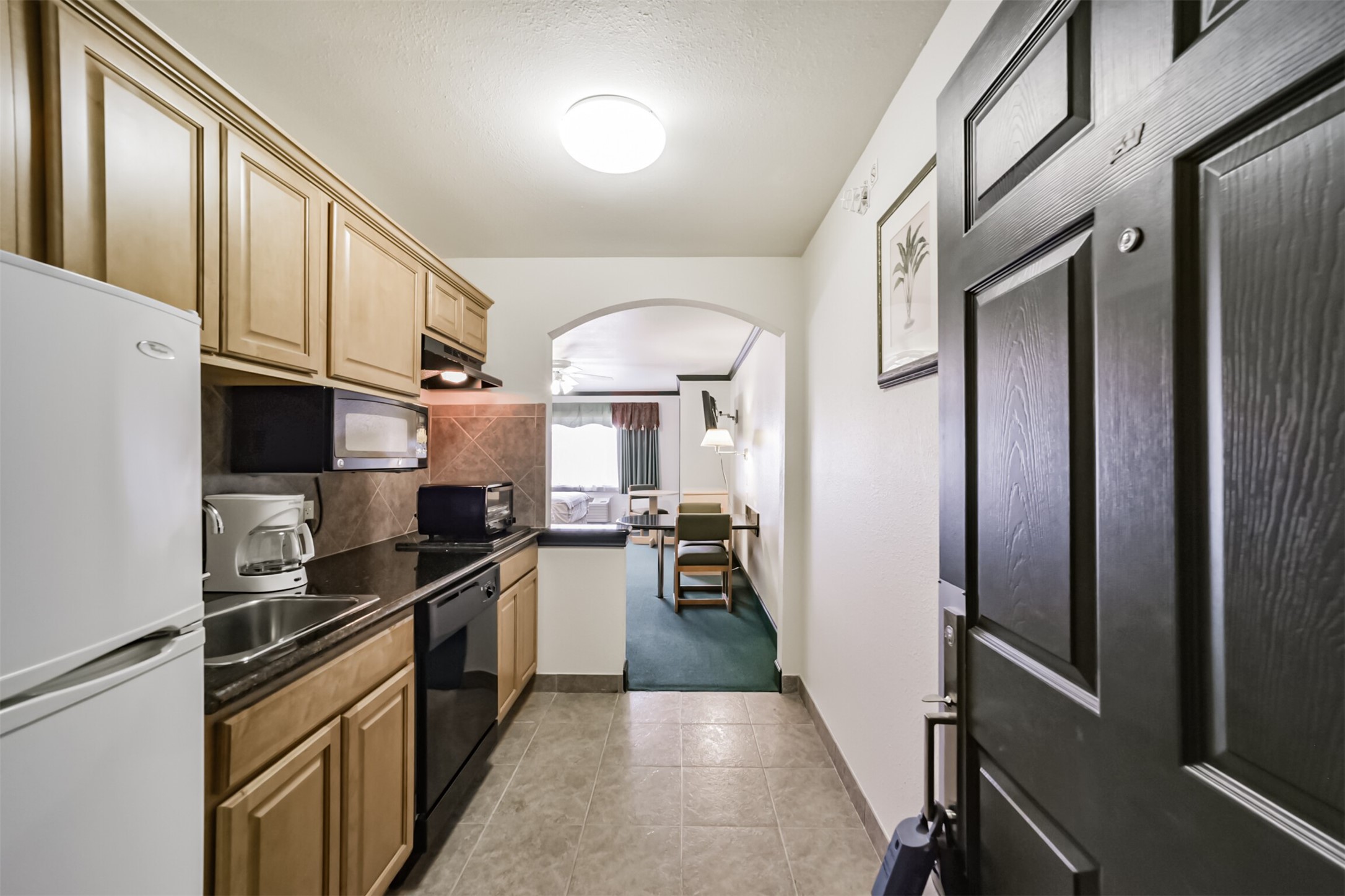 1025 Swanson Street, Unit 309 Houston, TX 77030 - Photo 5 of 21 a kitchen with stainless steel appliances granite countertop a refrigerator a sink dishwasher a stove and white countertops with wooden floor