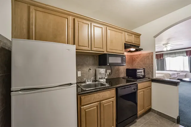 a kitchen with granite countertop a refrigerator and a sink