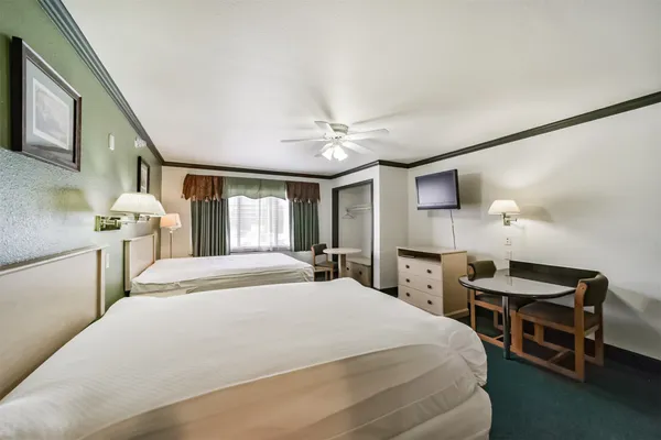 a bedroom with a bed desk and a window