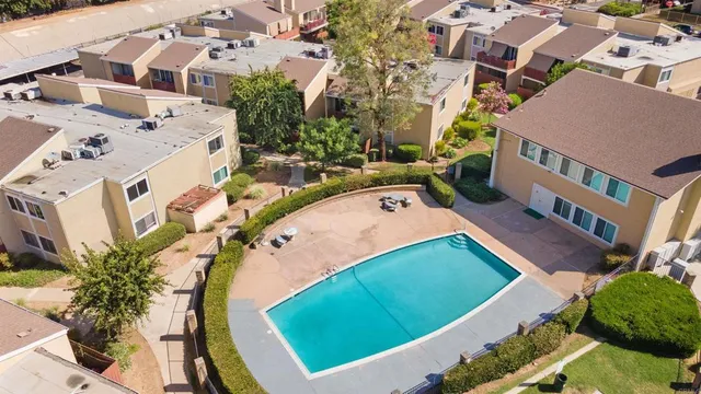an aerial view of a house with swimming pool and outdoor seating