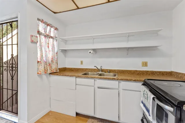 a view of a kitchen with cabinets and wooden floor