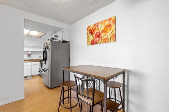 a view of a dining room with furniture and a refrigerator