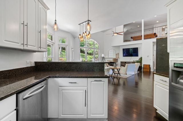 a kitchen with a table chairs and white cabinets