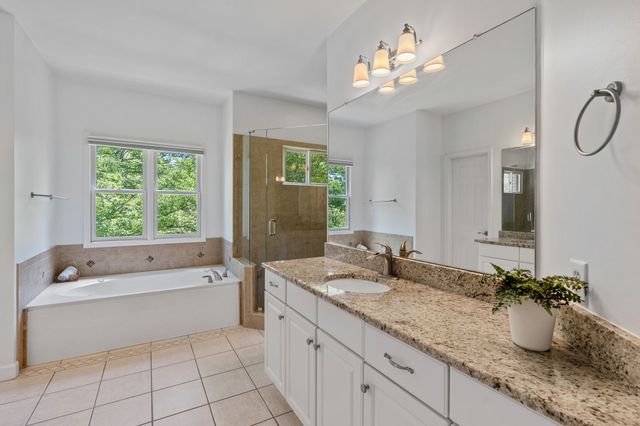 a bathroom with a granite countertop sink a large mirror and a bathtub with shower