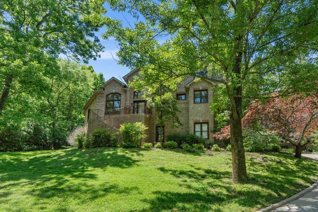 a house is sitting in middle od the grass