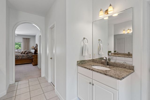 a en suite bathroom with a granite countertop sink and a mirror