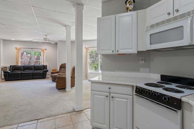 a kitchen with stainless steel appliances white cabinets and a stove top oven