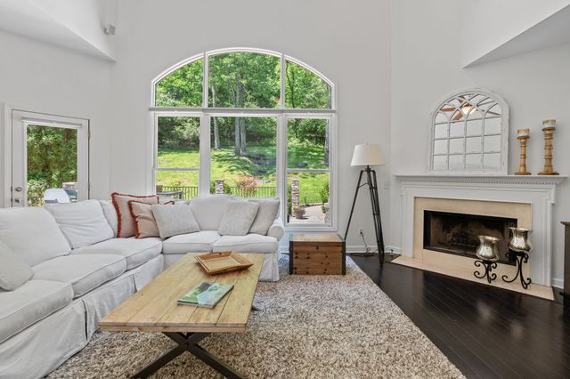 a living room with furniture a large window and a fireplace
