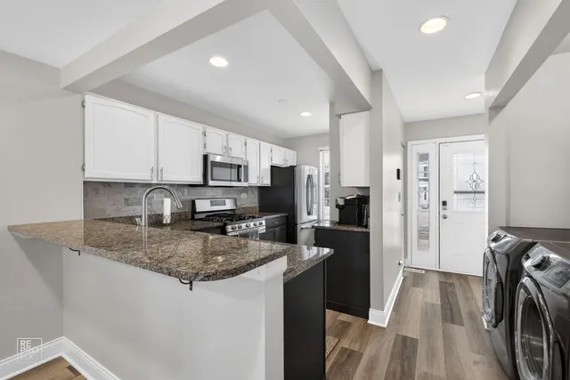 a kitchen with stainless steel appliances granite countertop a refrigerator stove microwave and sink