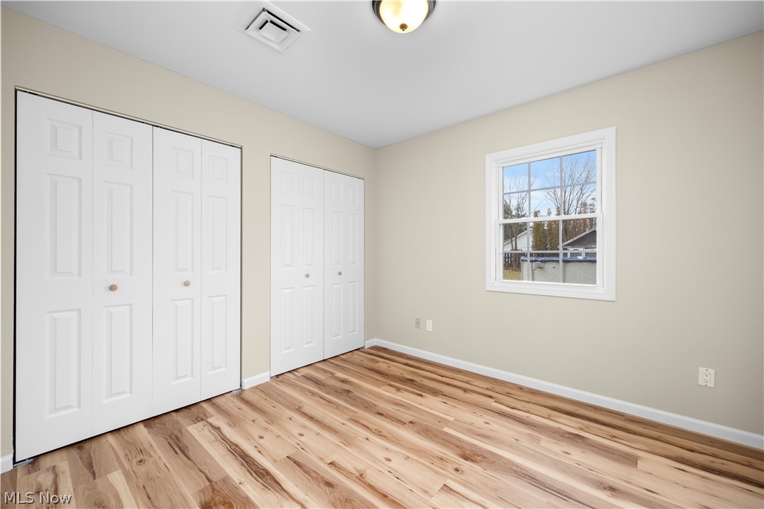 12452 Island Road Grafton, OH 44044 - Photo 23 of 39 Unfurnished bedroom with multiple closets and light wood-style floors