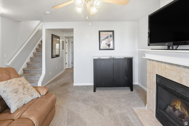 14820 175 East Draper, UT 84020 - Photo 15 of 39 Living area featuring carpet flooring, ceiling fan, a tiled fireplace, and stairs
