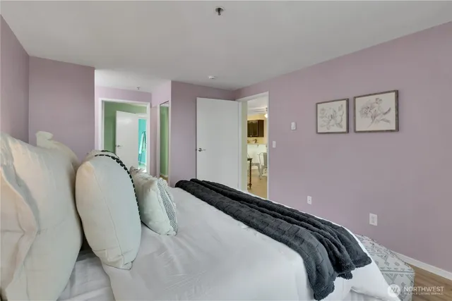 a bedroom with a bed and painting on the wall