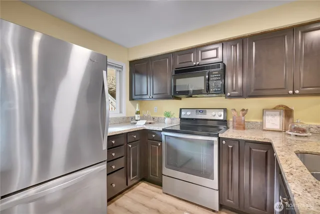 a kitchen with stainless steel appliances granite countertop a refrigerator stove and sink