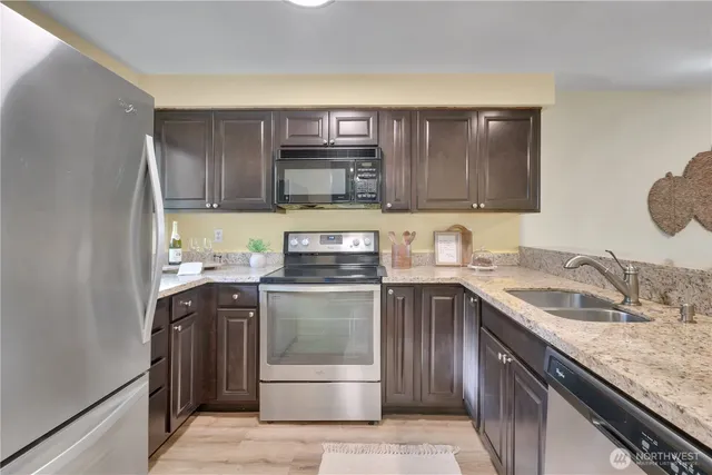 a kitchen with stainless steel appliances granite countertop a sink stove and cabinets